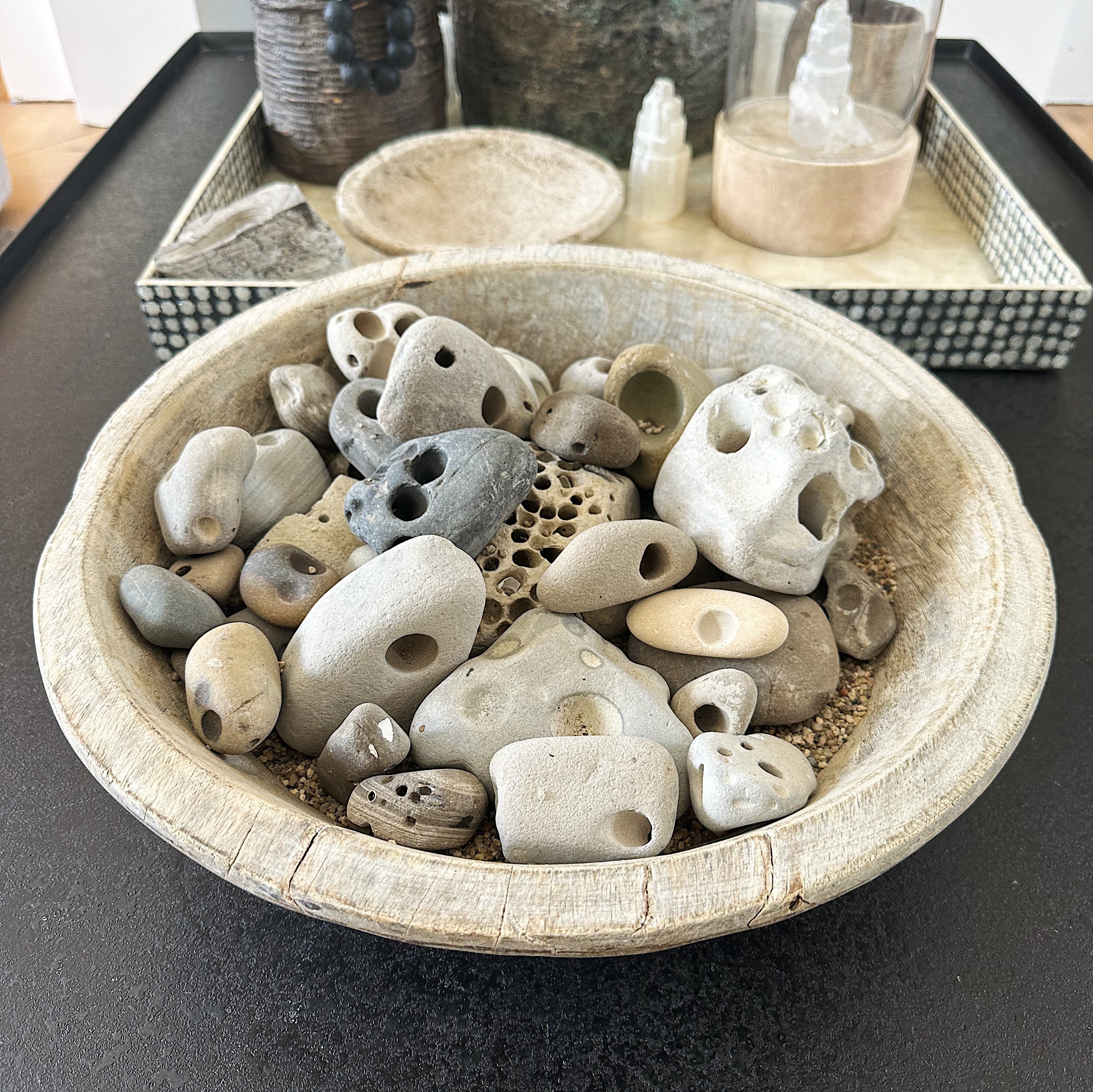 Antique wooden bowl with gathered rocks from the beach